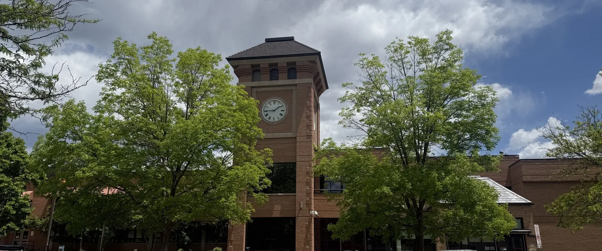 A brick clock tower in Durango, Colorado, under a cloudy summer sky